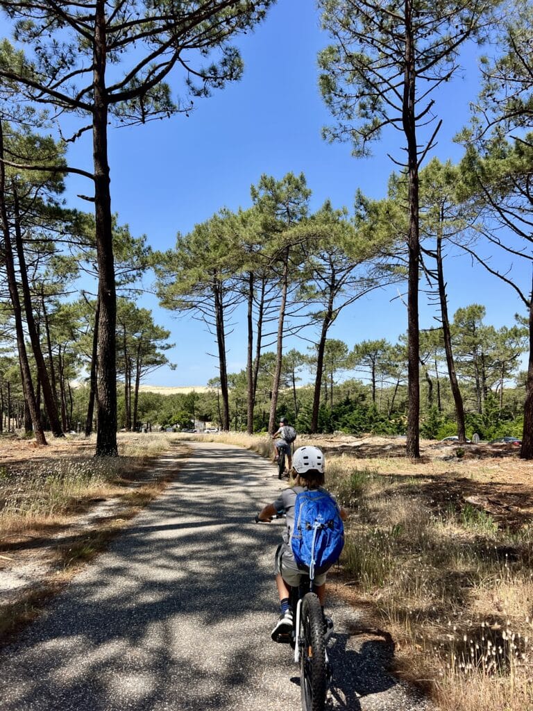enfants sur des vélos le long de la vélodyssée sous les pins entre Lacanau et le Porge Océan